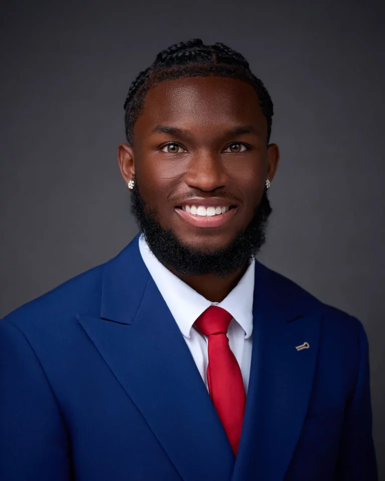 Professional corporate headshot of a smiling man in a blue suit and red tie, DFW on-site headshot event