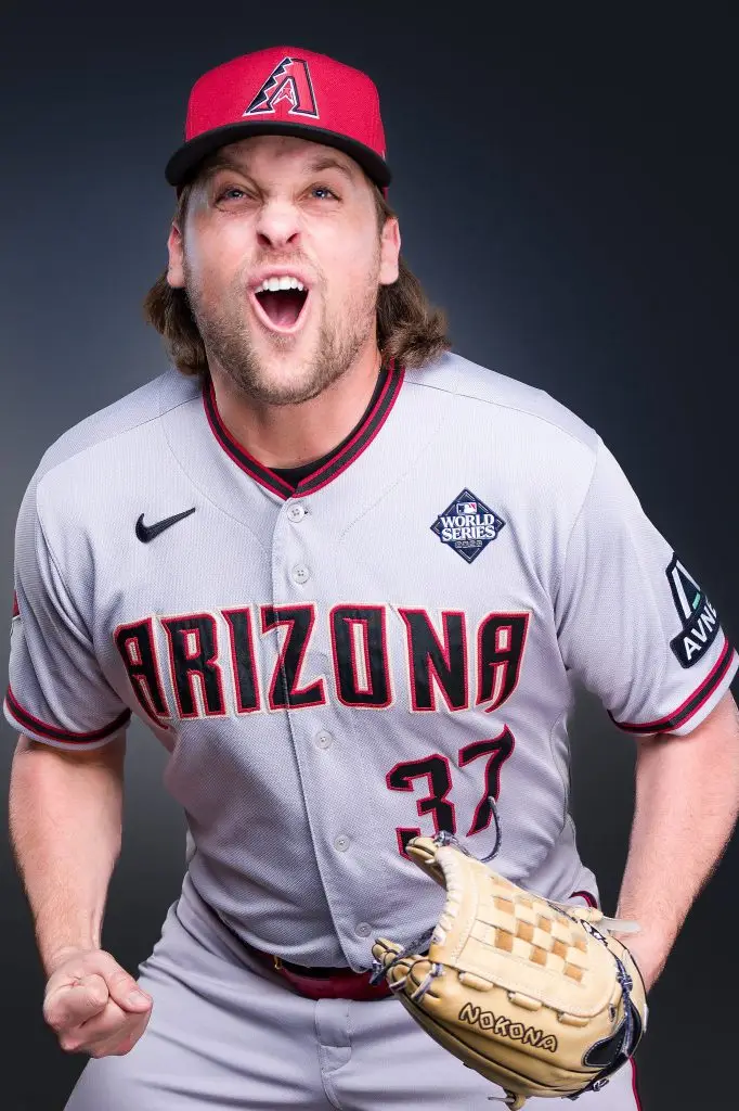 Professional baseball athlete in uniform reacting during a studio media-day portrait session.