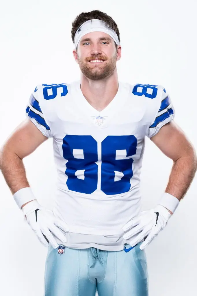 Professional football player in uniform photographed against a light studio background.
