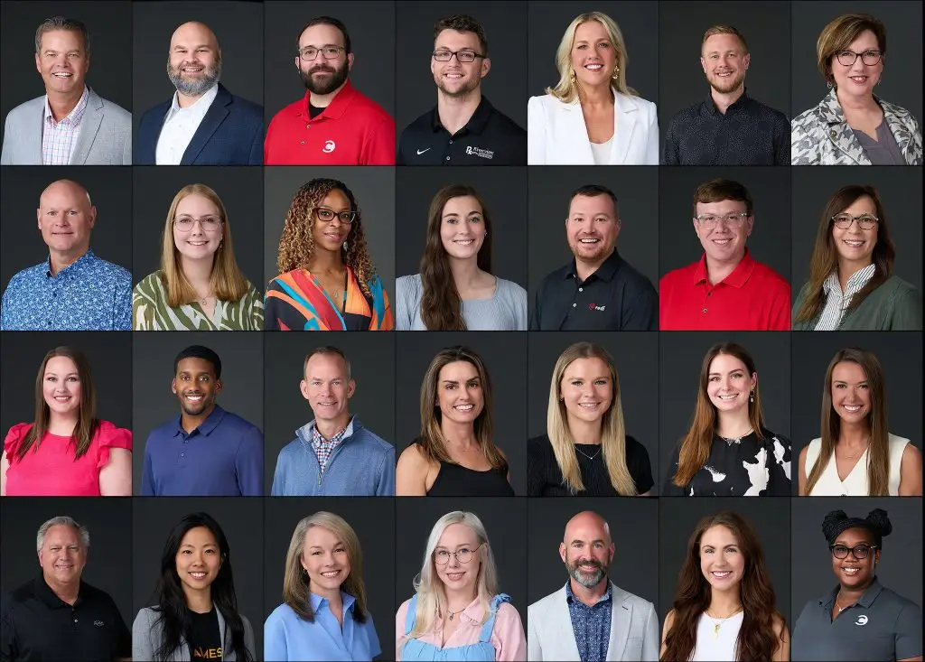 Grid of 28 finished professional headshots of men and women, all photographed against the same dark gray background