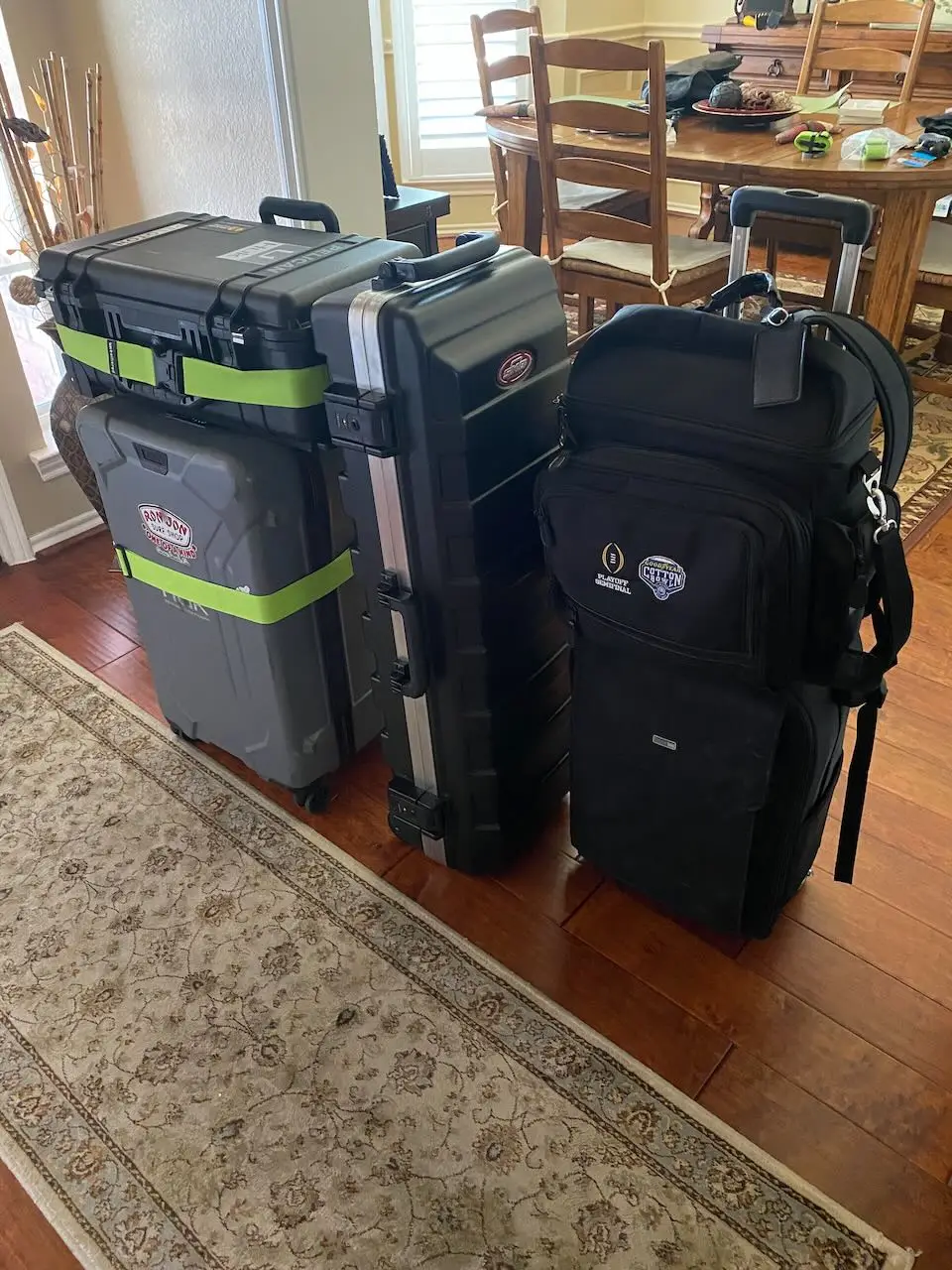 Rolling cases and equipment bags containing a compact professional headshot studio packed for travel